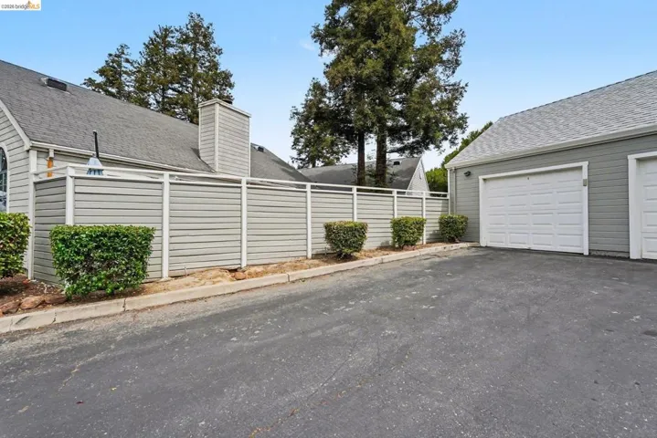 Asphalt driveway with direct access to a two-car garage featuring white panel doors