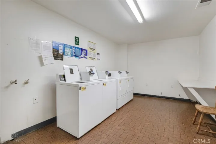  View of the community laundry room, conveniently located within the condo building. This shared space offers access to full-size washer and dryer units for residents.