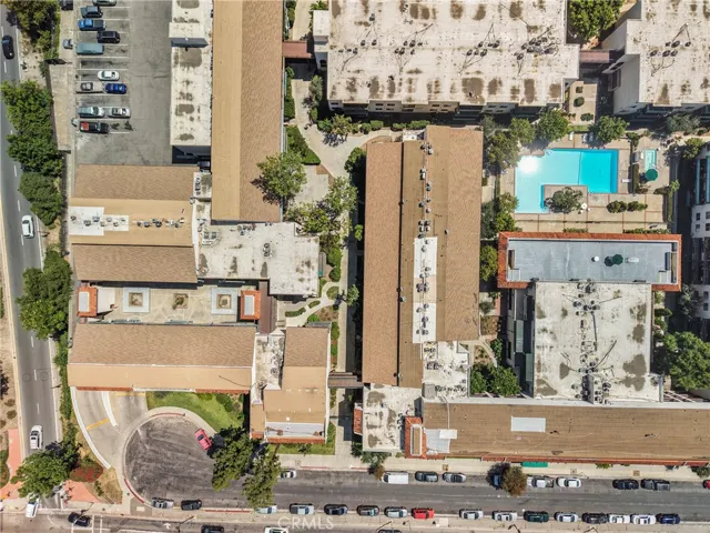 Aerial view of the condo community showing the full perimeter of the building. The pool and tennis courts are also clearly visible within the well-planned grounds.