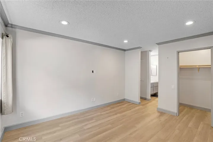 View of the primary bedroom showcasing the closet and the walkway leading to the bathroom. The layout offers a convenient flow between sleeping and bathing areas.