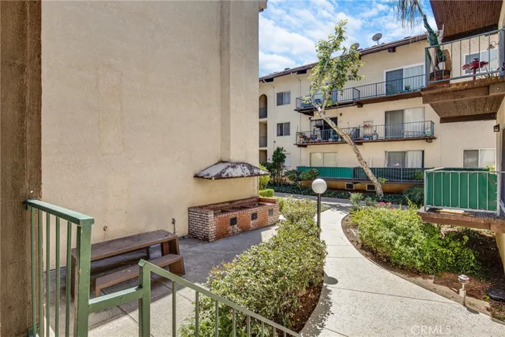 View of the community outdoor grill area, perfect for outdoor dining and entertaining. This amenity is conveniently located within the condo grounds.
