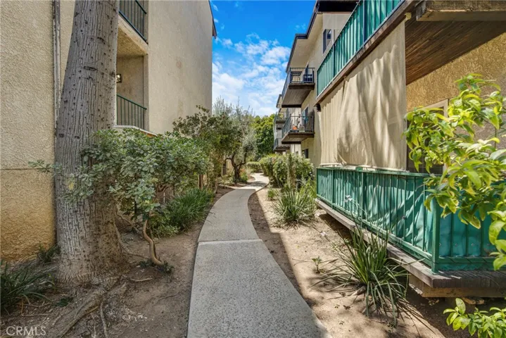 View of a tree-lined walking path within the main common areas of the condo community. The path provides convenient access to community amenities.