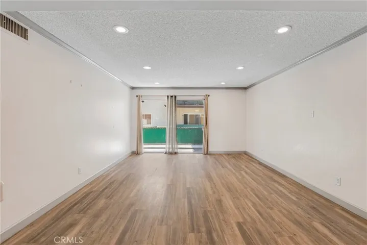 View of the living room looking out toward the private balcony. The balcony access brings in natural light and expands the living space outdoors.
