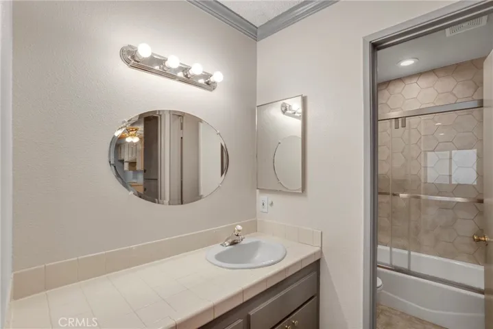 View of the primary bathroom featuring both the vanity area and the full tub with shower. The layout offers convenient access between the sink and bathing spaces.