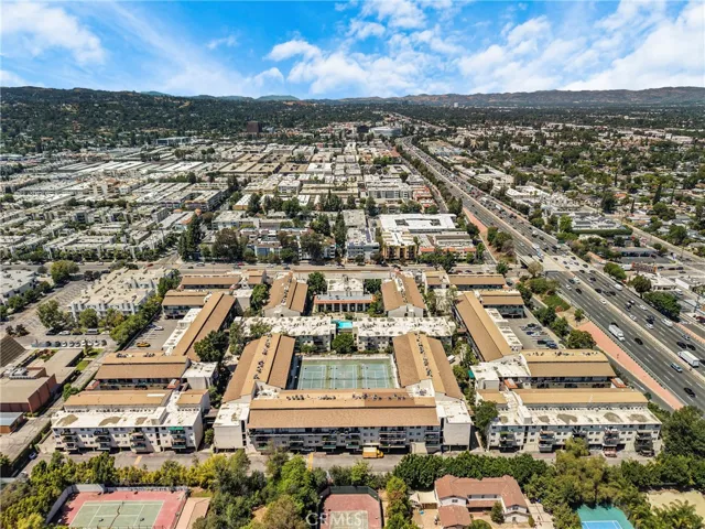 Back view of the condo showing the south side of the building, with White Oak Avenue visible on the north side. The view also features the 101 Freeway, surrounding neighborhood, and mountain views.