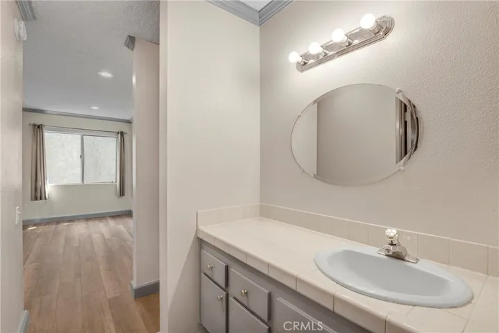 View of the vanity area in the primary bathroom, featuring built-in storage. The layout provides both style and practical organization.