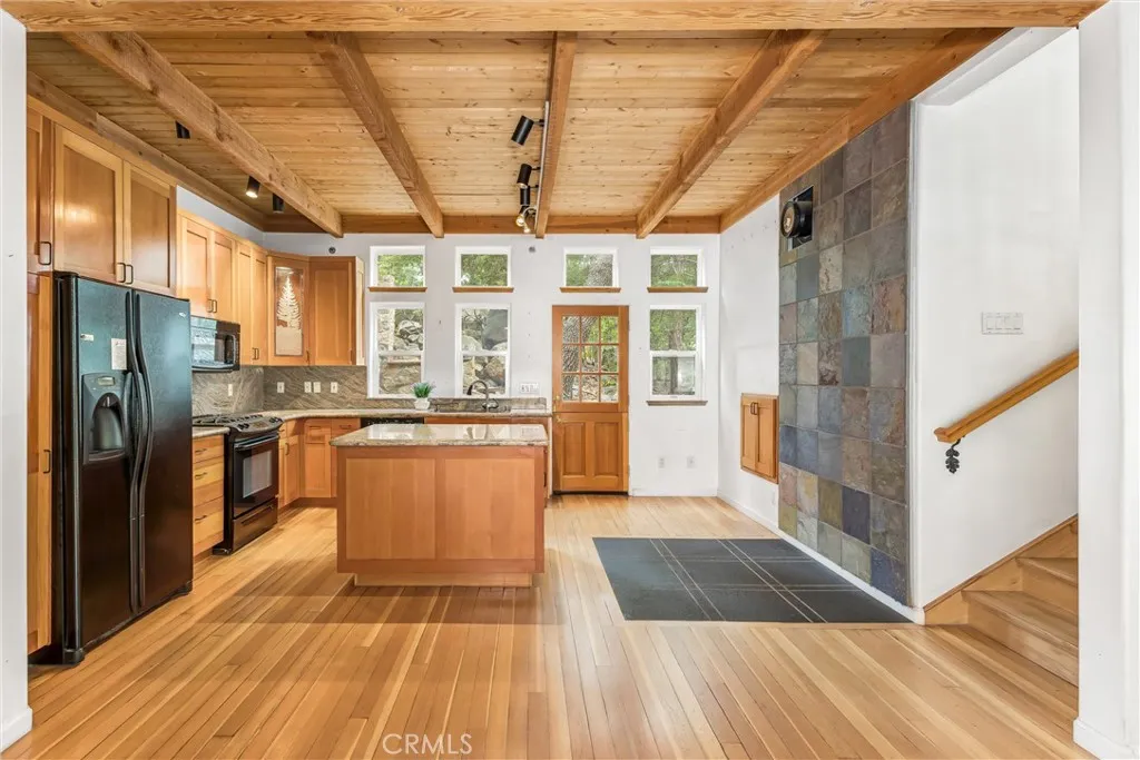 Kitchen with center island, refrigerator, stove, and microwave