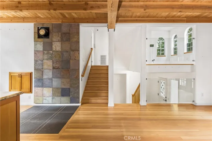Stairs from the kitchen and dining room up to an open area, and the living room beyond that.