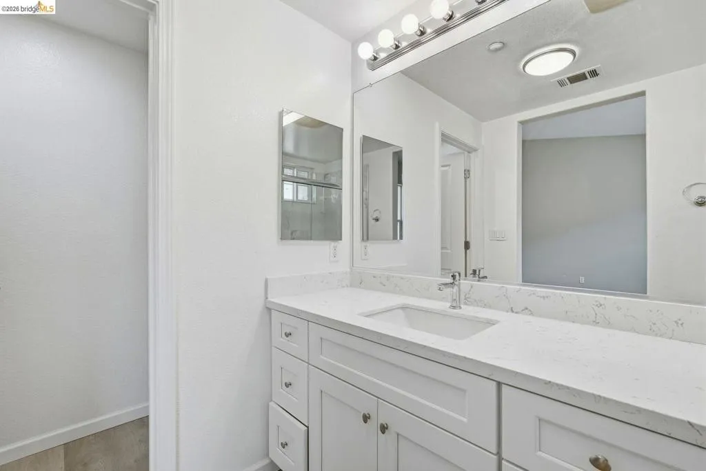 full bathroom with vanity, a shower, and light wood-style flooring