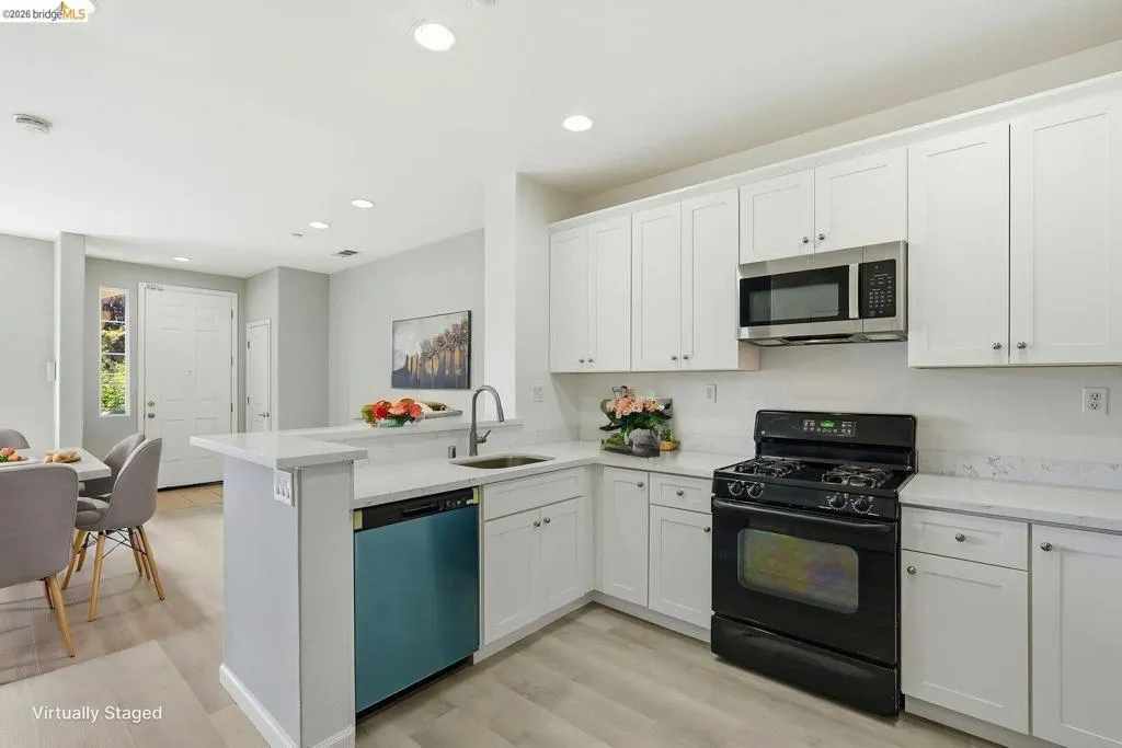 kitchen featuring black range with gas stovetop, white cabinets, light wood-style flooring, and recessed lighting