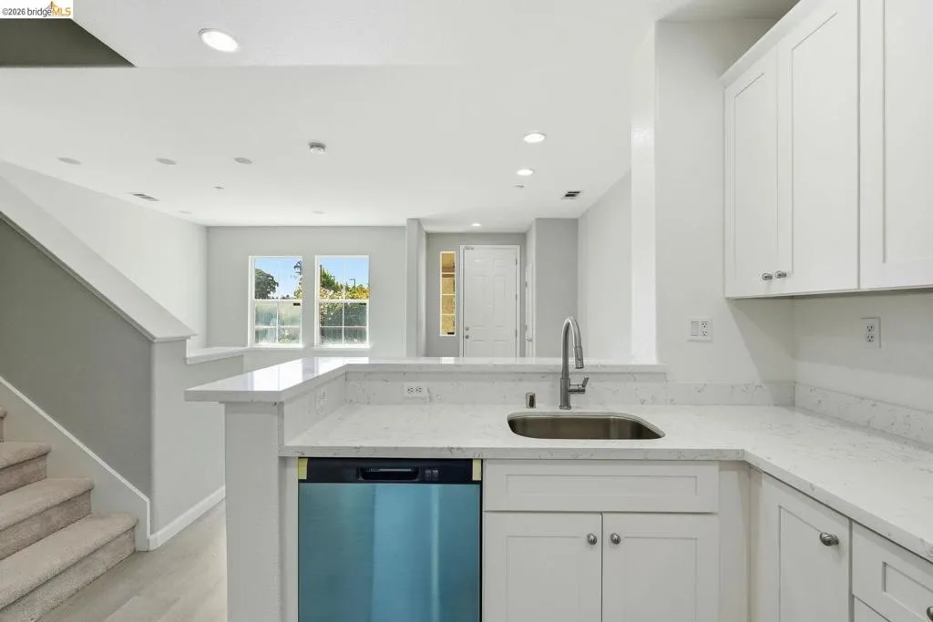 kitchen featuring white cabinetry, light stone counters, a peninsula, dishwashing machine, and recessed lighting