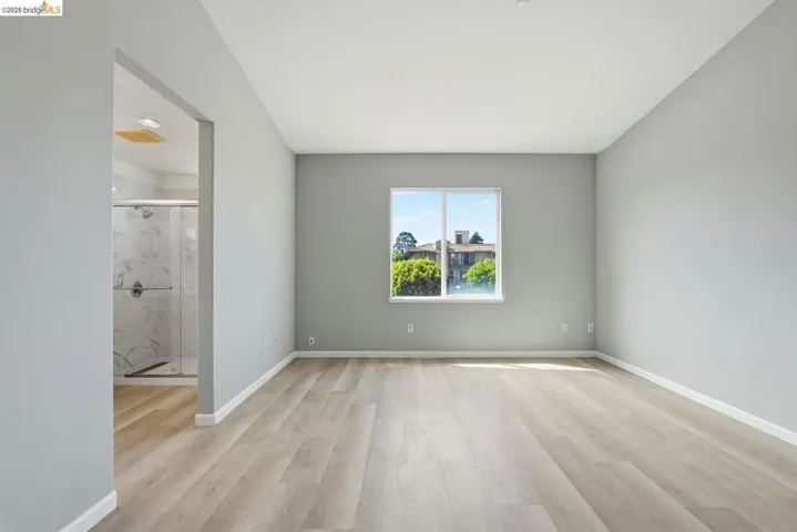 master bathroom featuring light wood-style floors and baseboards