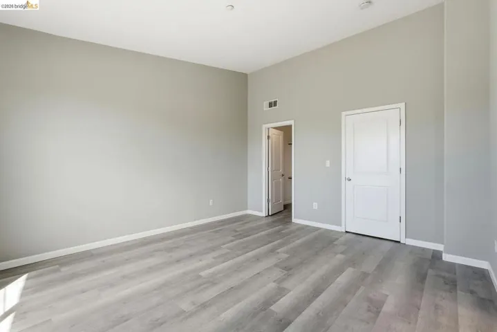 unfurnished bedroom with light wood-style flooring and a high ceiling