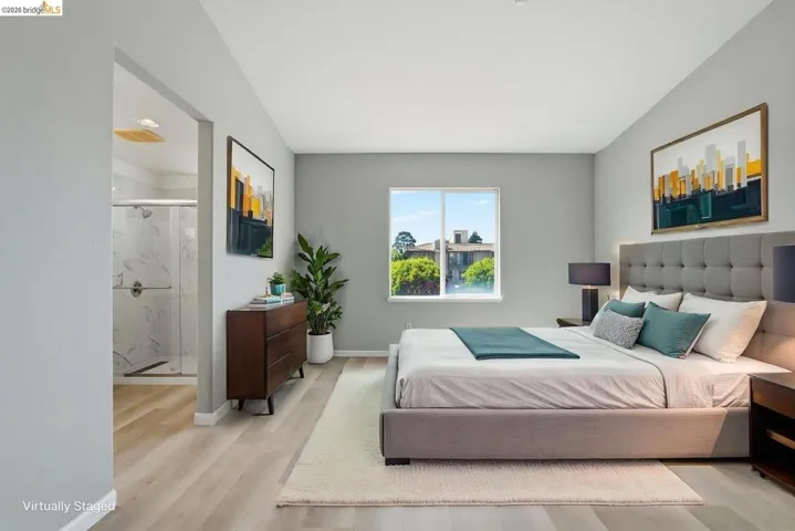 bedroom with light wood-style flooring and ensuite bathroom virtually staged