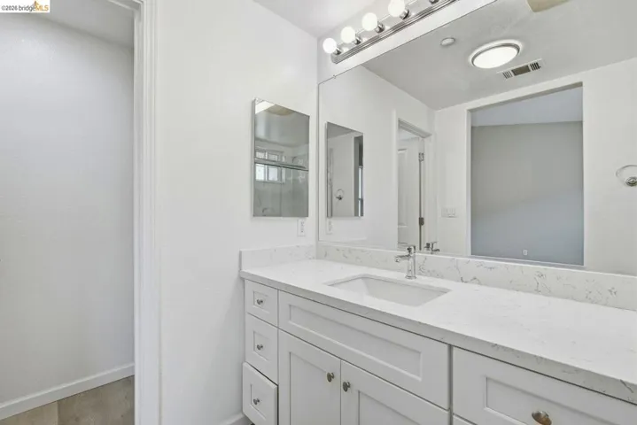 full bathroom with vanity, a shower, and light wood-style flooring