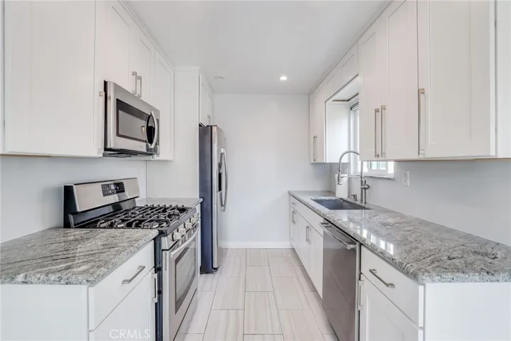 Kitchen with white cabinets and granite counters.