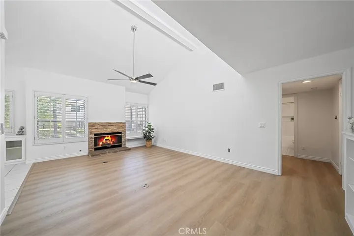 Open spacious living room with a cozy fireplace and vaulted ceilings.