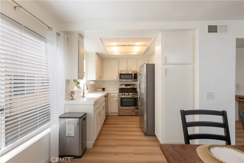 Clean Sunny Kitchen with Stainless Appliances and Garden Window