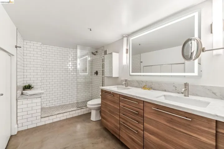 Double vanity featuring wood-finish cabinetry, integrated sinks, and a marble countertop