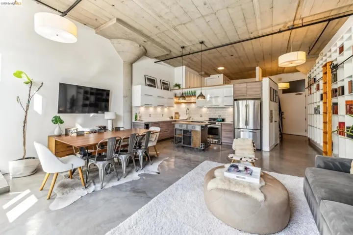 Open-concept living space with concrete flooring, exposed concrete ceiling, and industrial-style ductwork