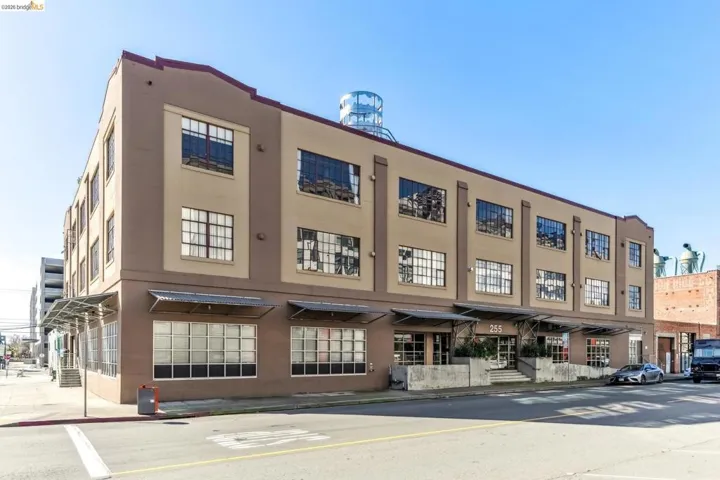 Three-story commercial building featuring a beige and brown facade with prominent grid-pattern windows
