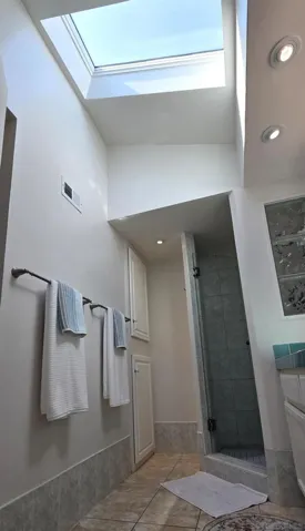 Primary bathroom with vaulted ceiling and skylight