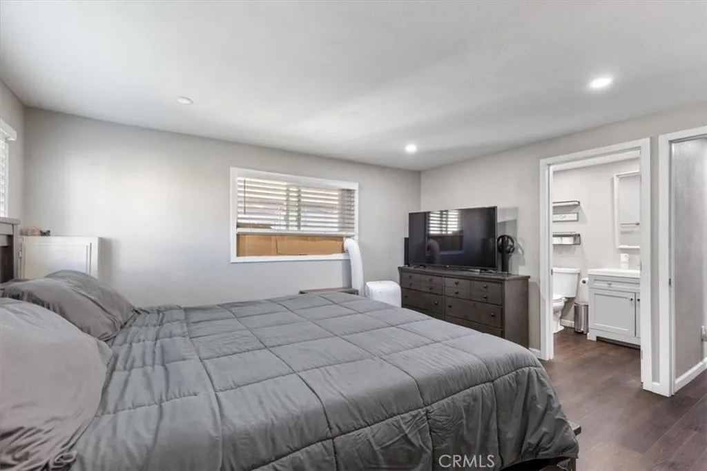 Primary Bedroom: Spacious primary suite with updated flooring, recessed lighting, walk-in closet, and private en suite bathroom.