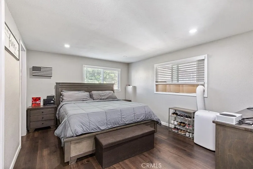 Primary Bedroom: Spacious primary suite with updated flooring, recessed lighting, walk-in closet, and private en suite bathroom.