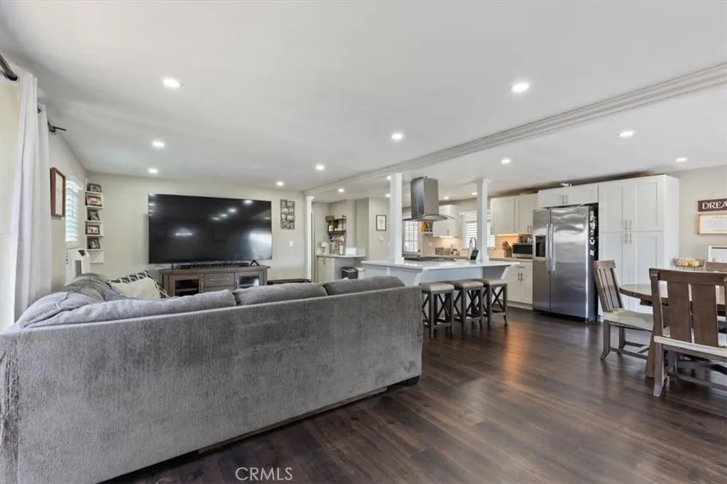 Living Room: Large open living area with updated flooring, recessed lighting, neutral tones, and direct flow to the kitchen and dining spaces.