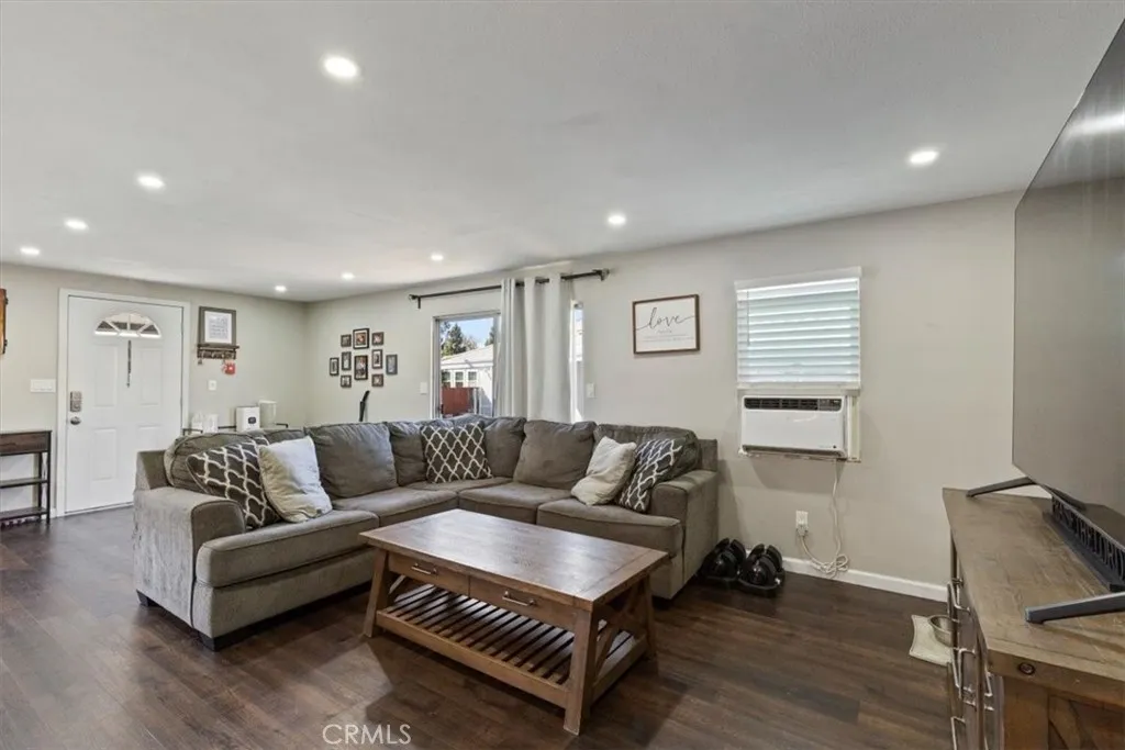 Living Room: Large open living area with updated flooring, recessed lighting, neutral tones, and direct flow to the kitchen and dining spaces.