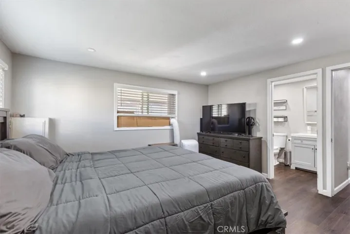 Primary Bedroom: Spacious primary suite with updated flooring, recessed lighting, walk-in closet, and private en suite bathroom.