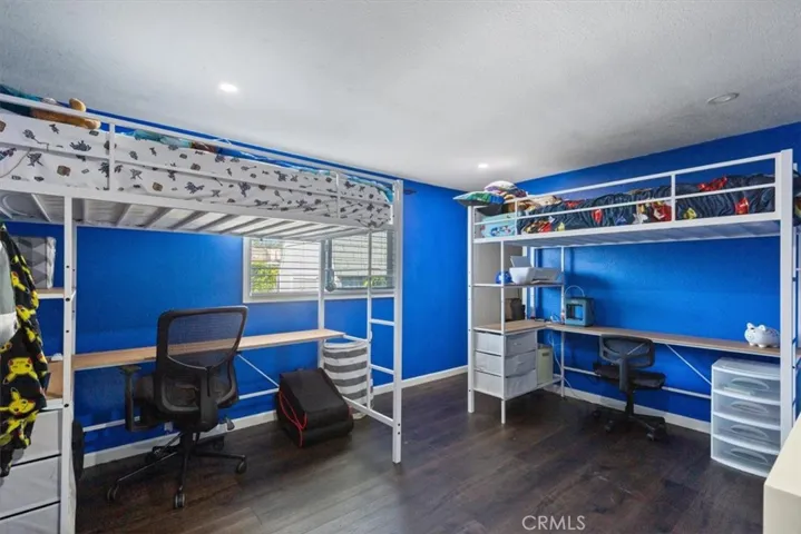 Spacious secondary bedroom with updated flooring, recessed lighting, neutral finishes, and flexible space for sleeping, studying, office use, or storage.