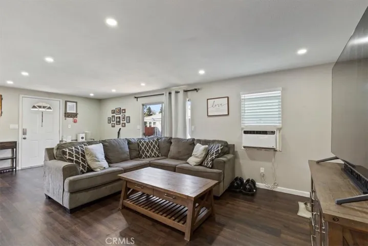 Living Room: Large open living area with updated flooring, recessed lighting, neutral tones, and direct flow to the kitchen and dining spaces.