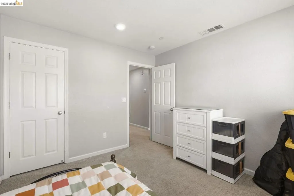 bedroom featuring light colored carpet and baseboards