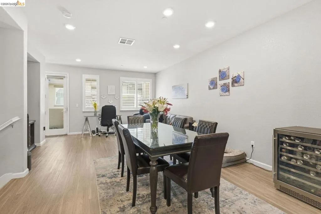 dining room featuring wine cooler, light wood-style flooring, recessed lighting, and a desk