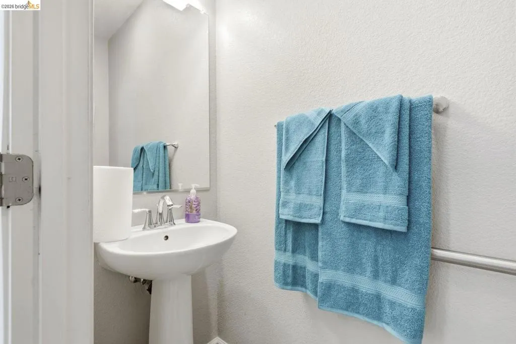bathroom featuring a textured wall and a sink