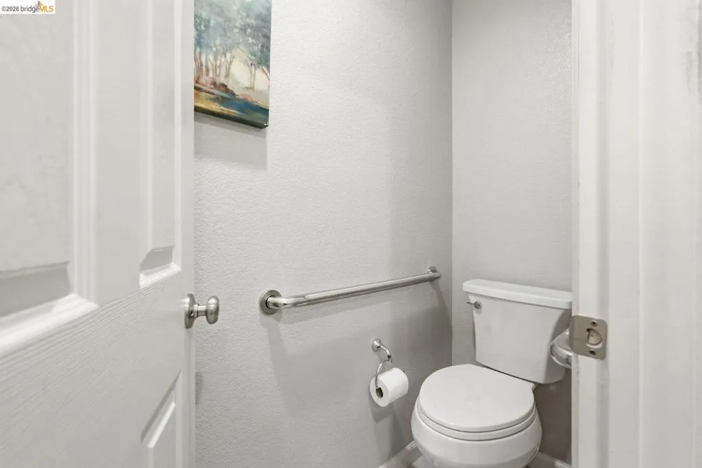 bathroom with toilet and a textured wall