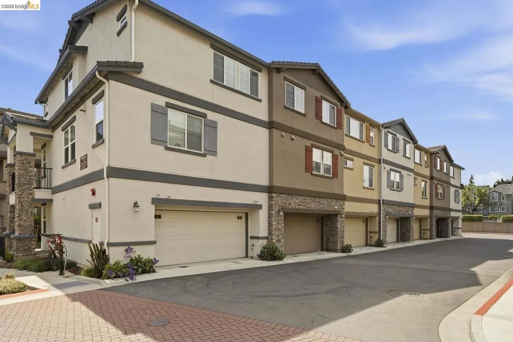 view of building exterior featuring a residential view and driveway