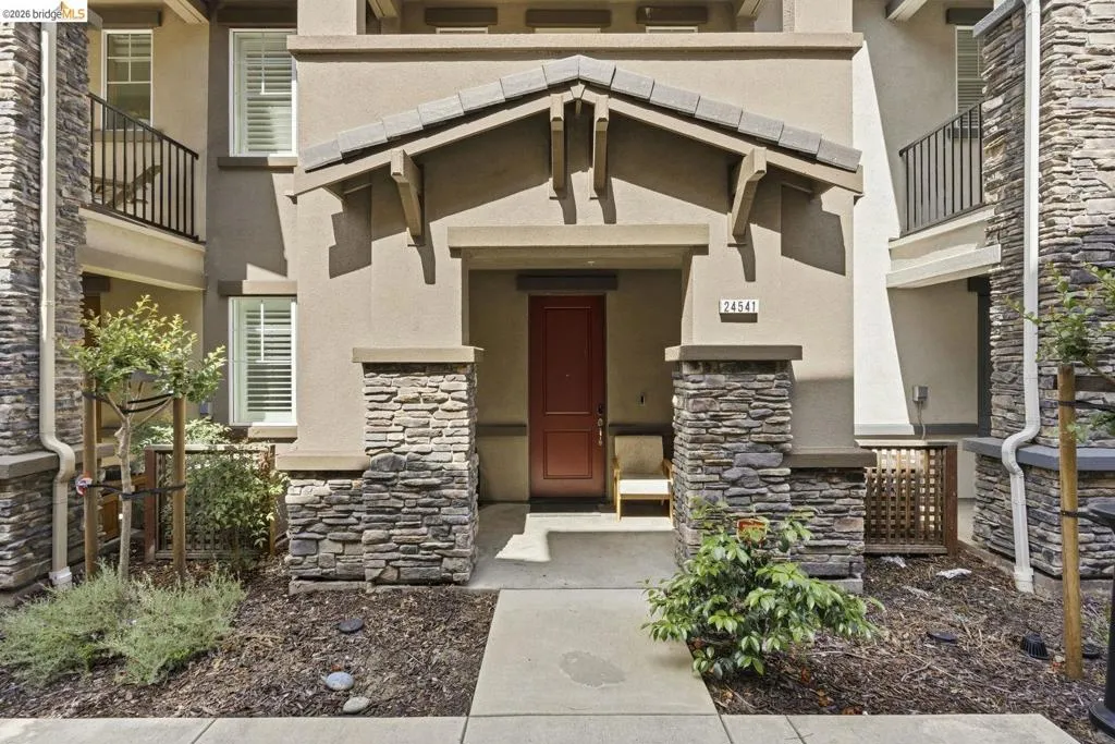 property entrance featuring stone siding and stucco siding