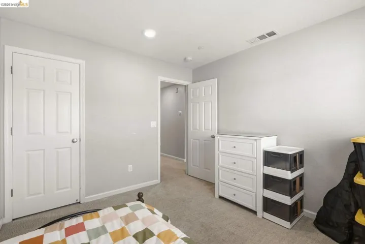 bedroom featuring light colored carpet and baseboards