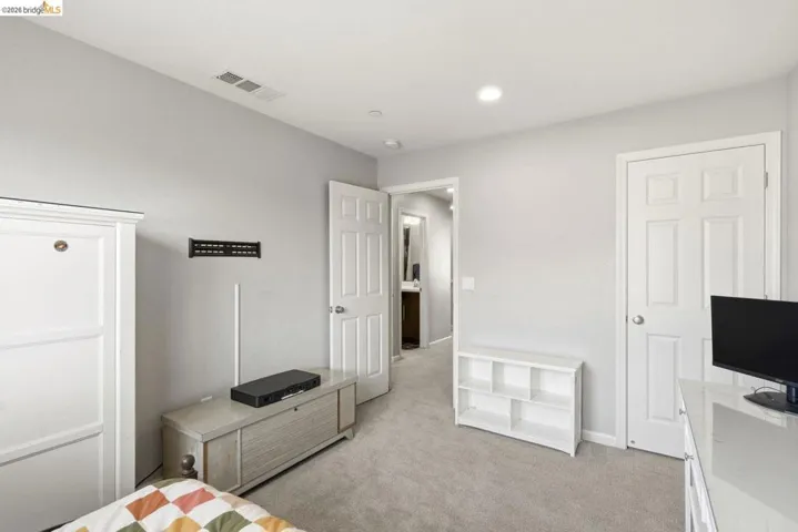 bedroom with light colored carpet and baseboards