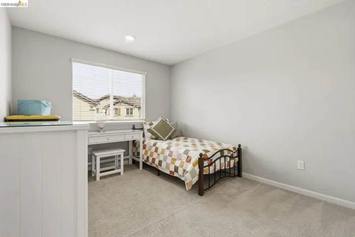 bedroom featuring light carpet and baseboards