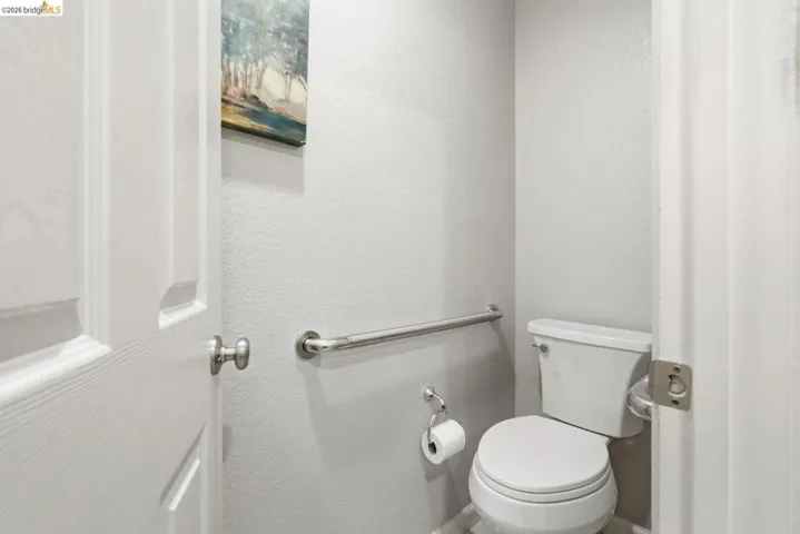 bathroom with toilet and a textured wall