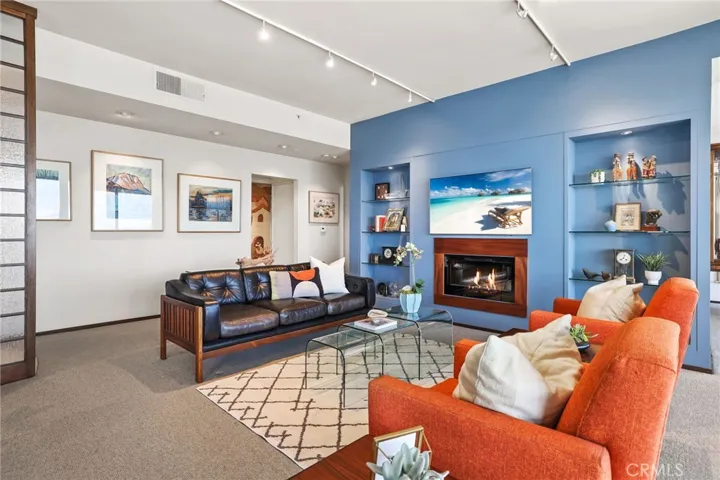 Built in glass shelving displays artwork beautifully.  The electric fireplace is framed in hardwood and adds warm and texture.