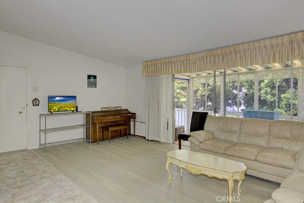 Another view of the living room. Front door can be partially seen at far left.