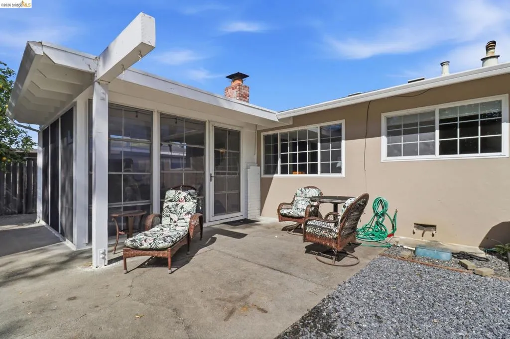 Expansive concrete patio with an attached screened enclosure and exposed beam structure