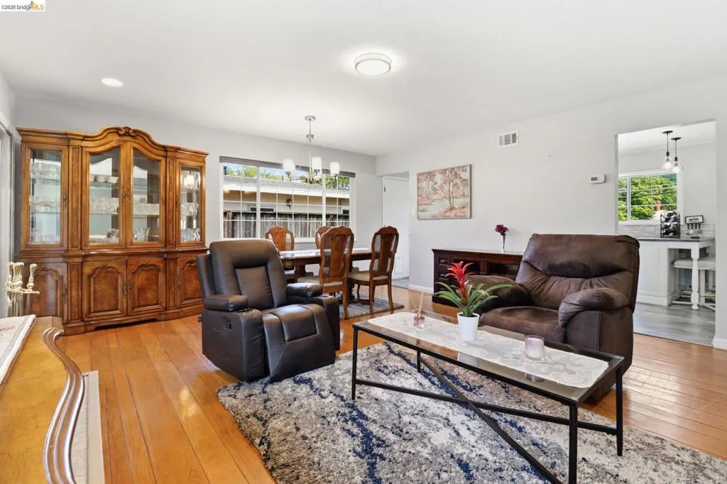 Bright living area featuring wood-finish flooring, recessed lighting, and a large picture window