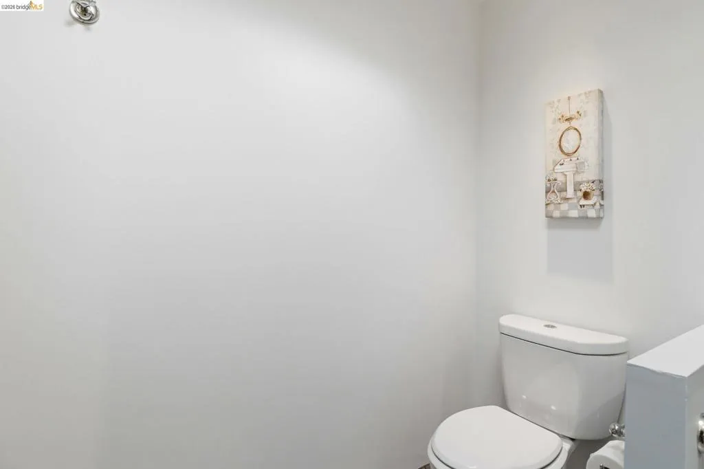 White toilet fixture with chrome flush handle and white tank lid