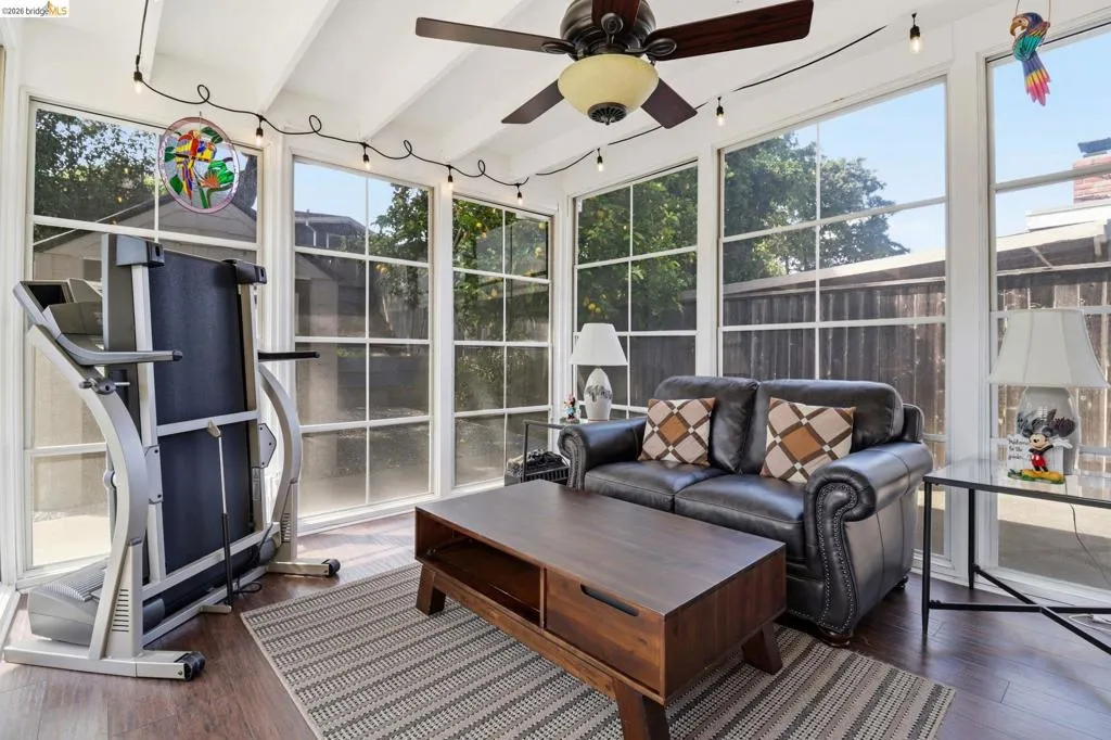 Sunroom with wood-finish flooring and a vaulted ceiling with exposed beams
