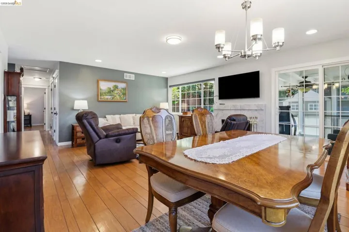 Open-concept living space featuring wood-finish flooring, a white mantel, and sliding glass doors